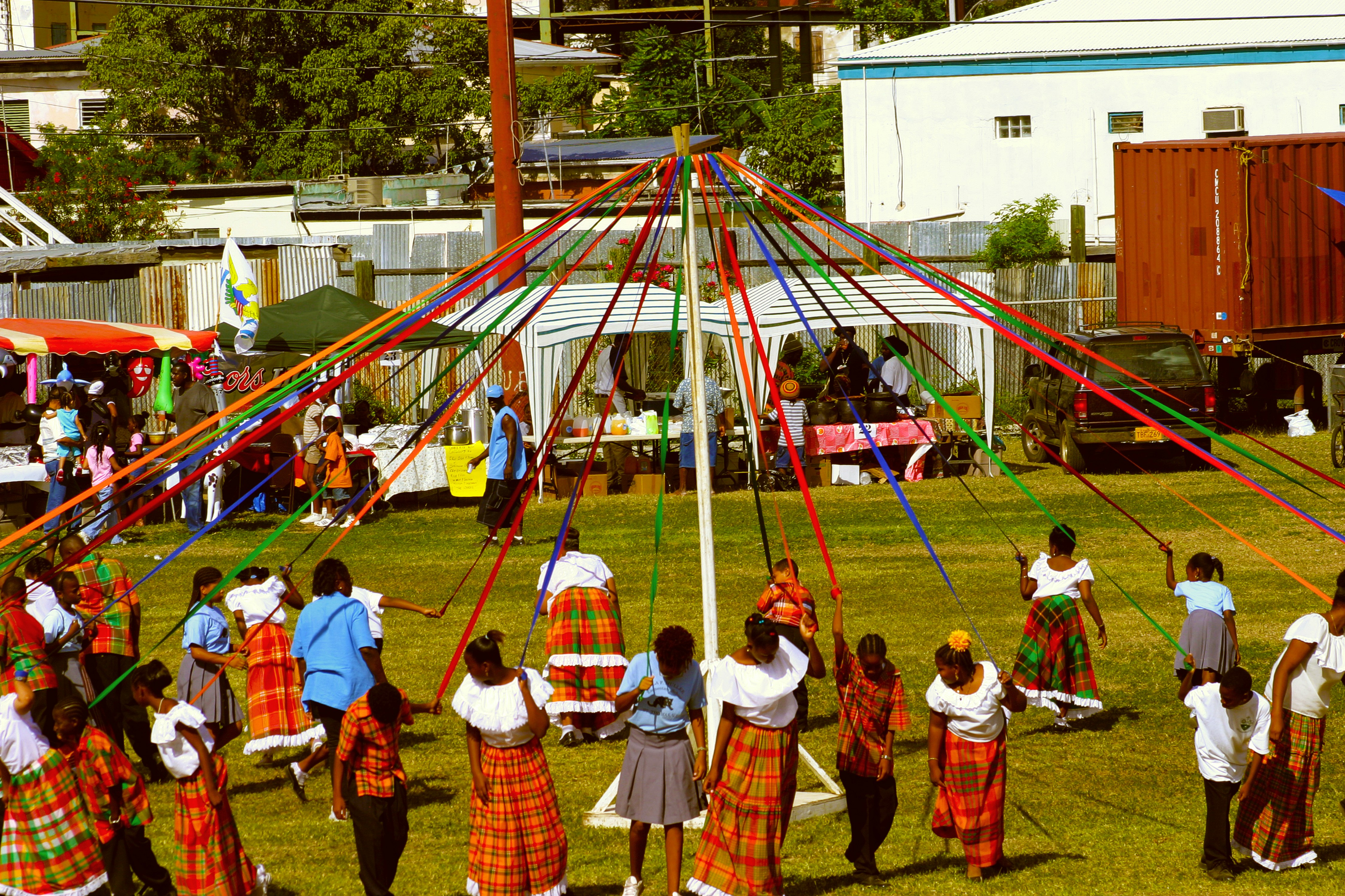 A group of people dancing in a May Pole ceremony.